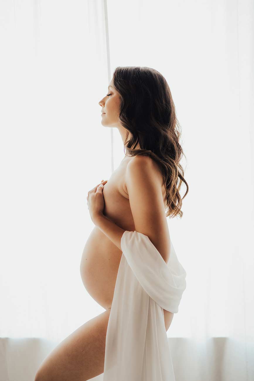 Elegant Maternity Photo with Natural light window and sheet