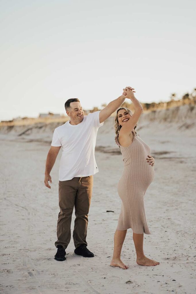 Couple dancing on Jacksonville beach during maternity session