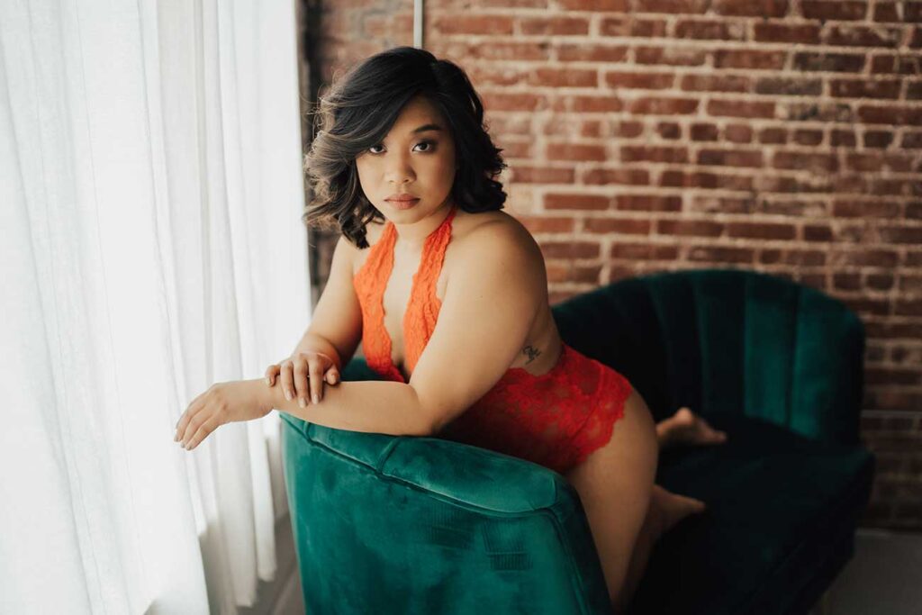 Girl in orange  lingerie on green velvet couch