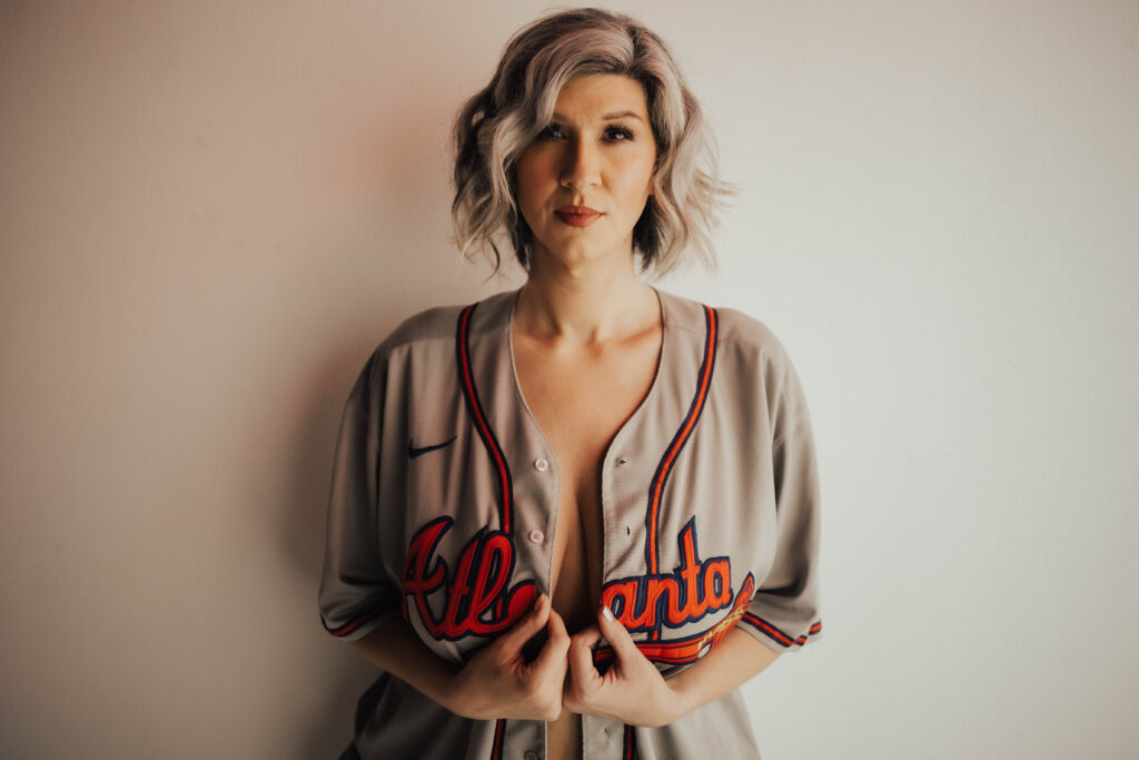 Boudoir photoshoot of woman in baseball jersey.