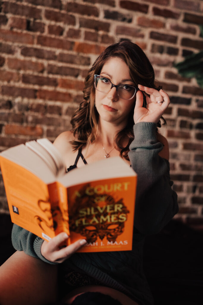 Woman holding glasses and a book in a unique boudoir photoshoot