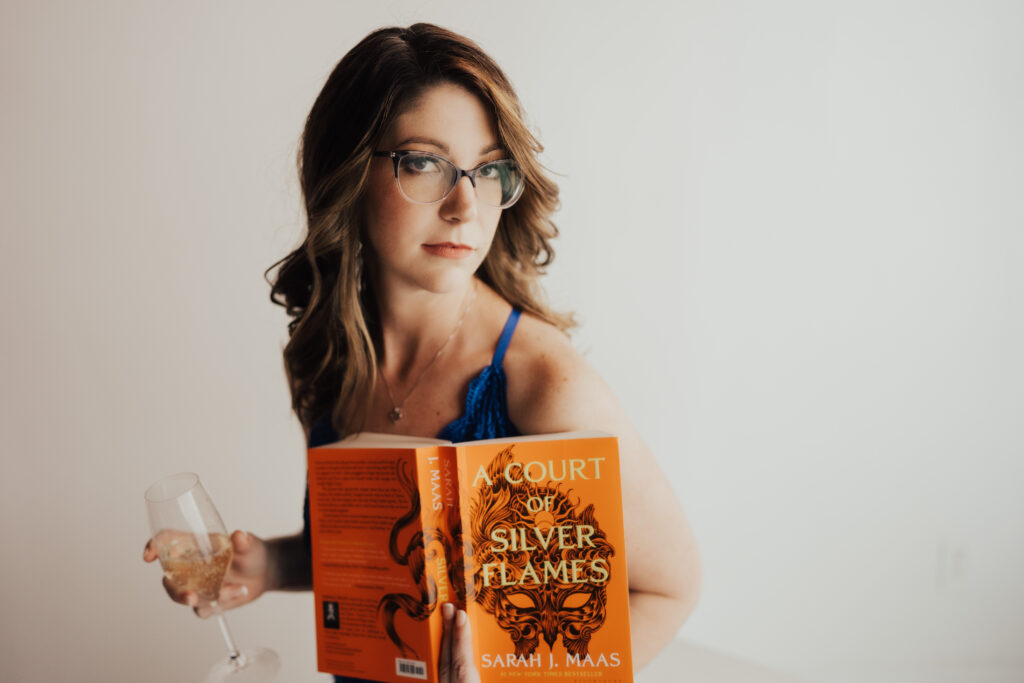 Woman posing a unique boudoir photoshoot with a book and champagne