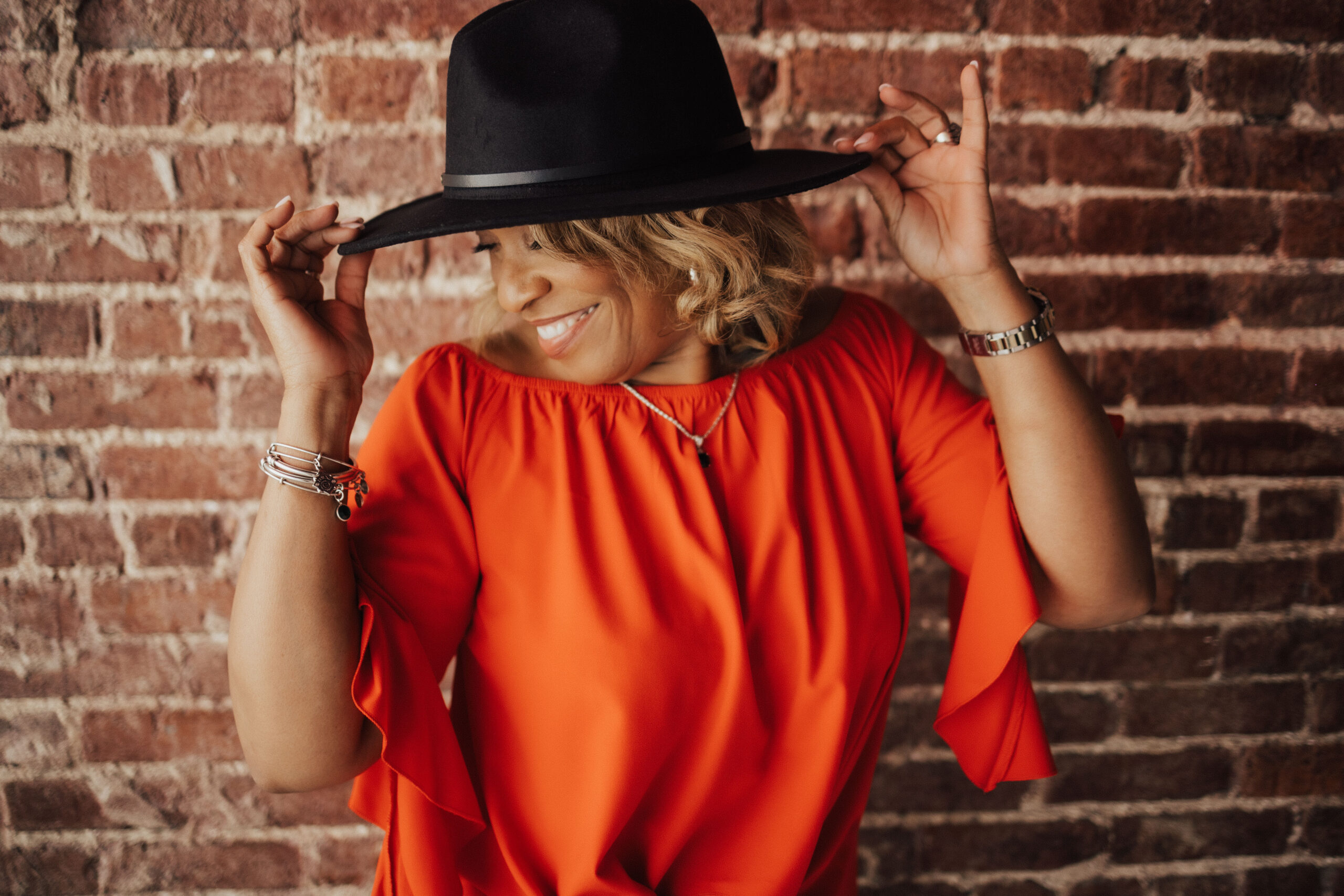woman holding hat posing for mature boudoir photoshoot