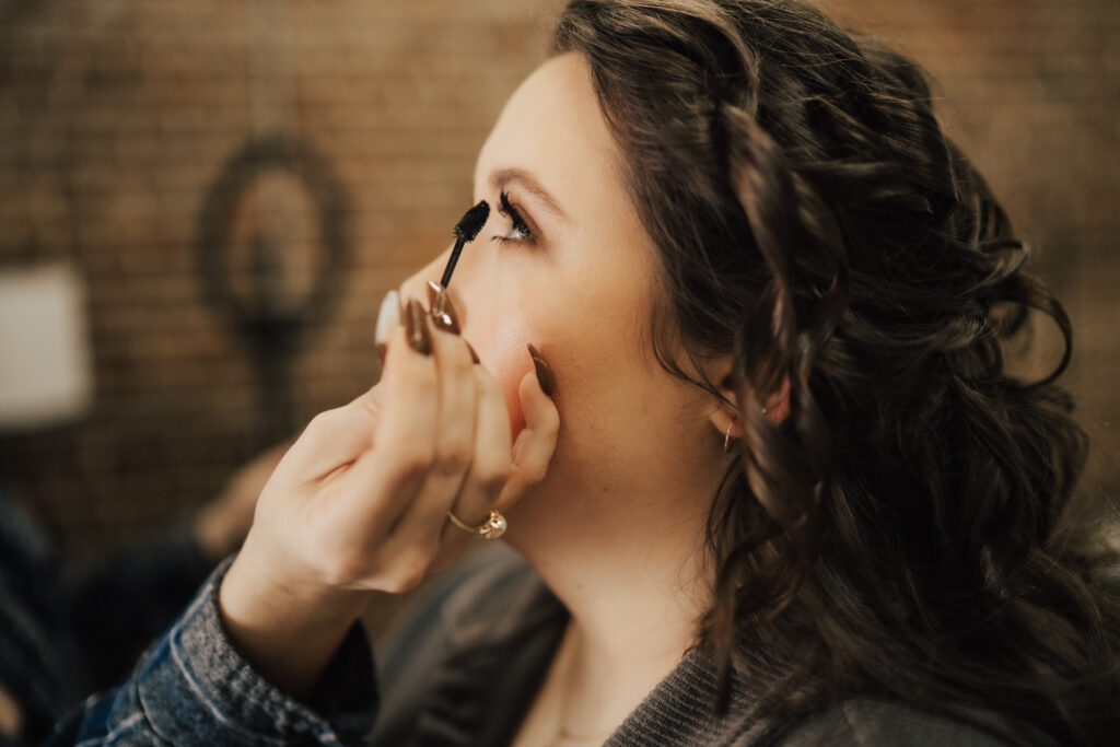 woman getting her makeup done as part of her boudoir experience