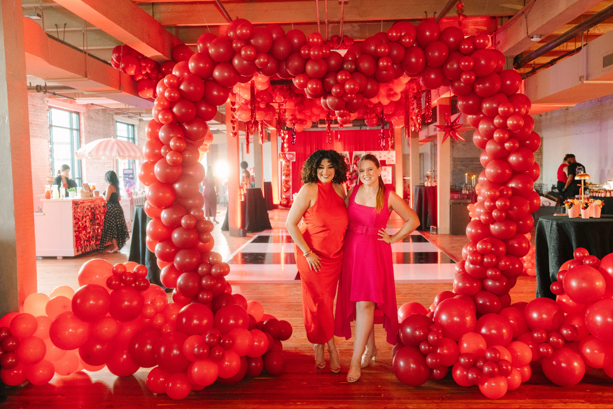 women standing in front of balloon arch at galentine's day girls night out event