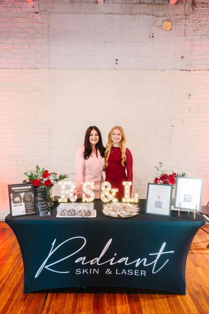 women standing behind booth at galentine's day girls night out event